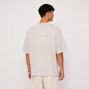 Vue arrière du t-shirt Tsitsit beige oversize Eliorness avec la grande flamme Aech Sheli de Rabbi Nahman brodée au dos en broderie ton sur ton beige.