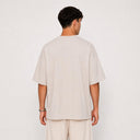 Vue arrière du t-shirt Tsitsit beige oversize uni Eliorness montrant la coupe moderne sans motif et le tombé d'épaules bas.