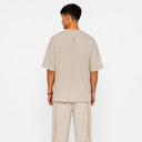 Vue arrière du t-shirt Tsitsit beige effet lin Eliorness montrant la mini flamme Aech Sheli brodée délicatement en haut du dos.