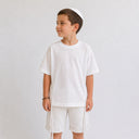 T-shirt Tsitsit enfant blanc effet lin, coupe oversize ample de la marque Eliorness avec fentes zippées latérales.