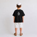 Vue arrière du t-shirt Tsitsit noir enfant oversize Eliorness montrant la grande flamme Aech Sheli brodée au dos.
