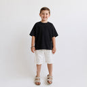 T-shirt Tsitsit noir oversize pour enfant Eliorness avec coupe ample tendance de style streetwear et fermetures éclair latérales.