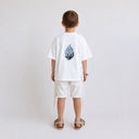 Vue arrière du t-shirt Tsitsit blanc enfant oversize Eliorness mettant en valeur la grande flamme bicolore bleue brodée au dos.