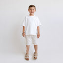 T-shirt Tsitsit blanc oversize pour enfant Eliorness avec coupe ample tendance de style streetwear et fentes latérales.