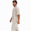 Profil du t-shirt Tsitsit Effet Lin beige Eliorness sur fond blanc : zip latéral en métal et deux tsitsit aux coins avant et arrière, maille jersey chinée légère.