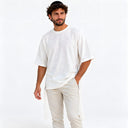 Homme portant le t-shirt Tsitsit Effet Lin blanc Eliorness, vue de face sur fond blanc : coupe oversize, épaules tombantes, zips latéraux et tsitsit blancs.