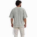 Vue de dos du t-shirt Tsitsit Effet Lin gris menthe Eliorness sur fond blanc, avec la flamme Aech Cheli brodée grise au contour orange sous le col.