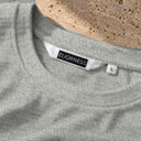 Détail de l'étiquette ELIORNESS au col du t-shirt Tsitsit Effet Lin gris menthe, tissu polyester et rayonne effet lin.